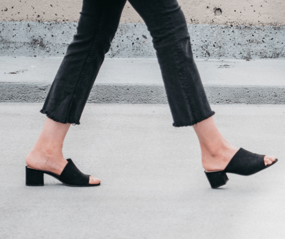 women walking on a road wearing black jeans and black colour block heel sandals